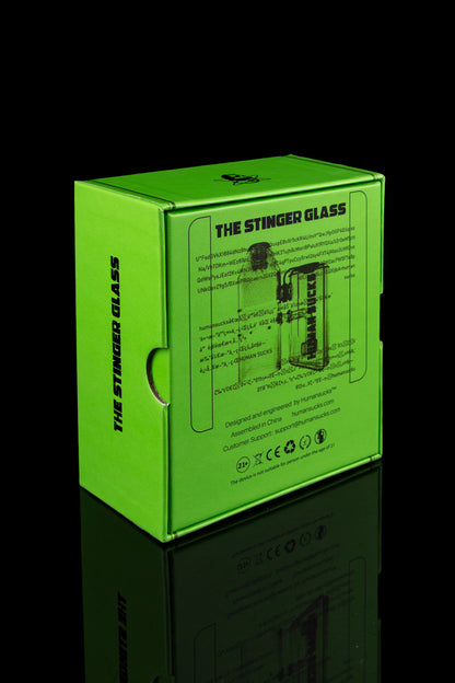 Bright green packaging box for “The Stinger Glass” cannabis accessory, displaying a repeating pattern of the brand’s logo and warning labels.