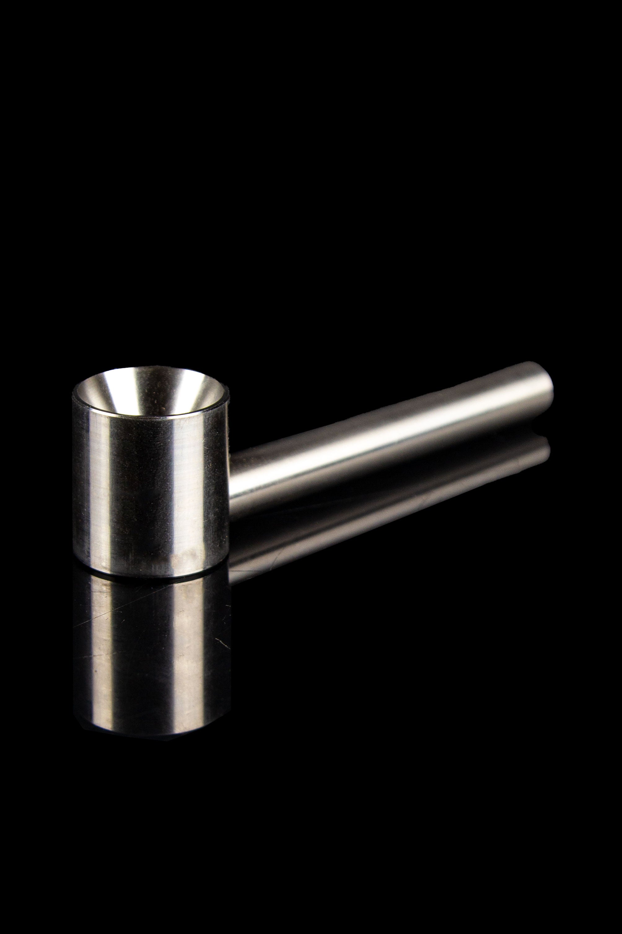 Silver cannabis oil burner pipe on a reflective black surface.