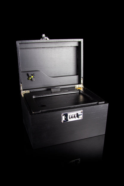 Black cannabis storage box with combination lock and visible buds inside.