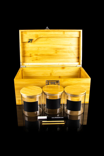 Wooden storage box with cannabis jars and accessories, displayed on a reflective surface.