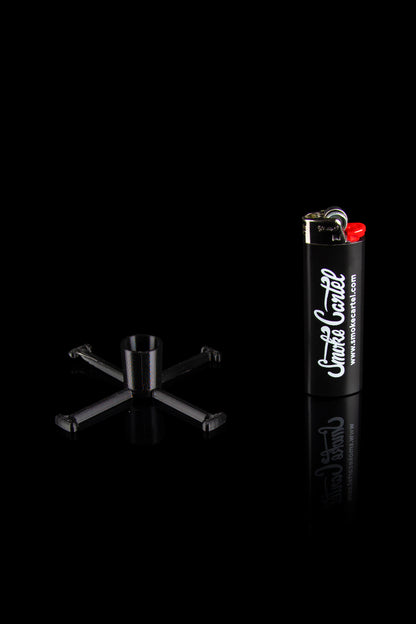 Black cannabis smoking accessories including a bubbler pipe and lighter with "Smoke Cartel" branding, isolated on a black reflective surface.