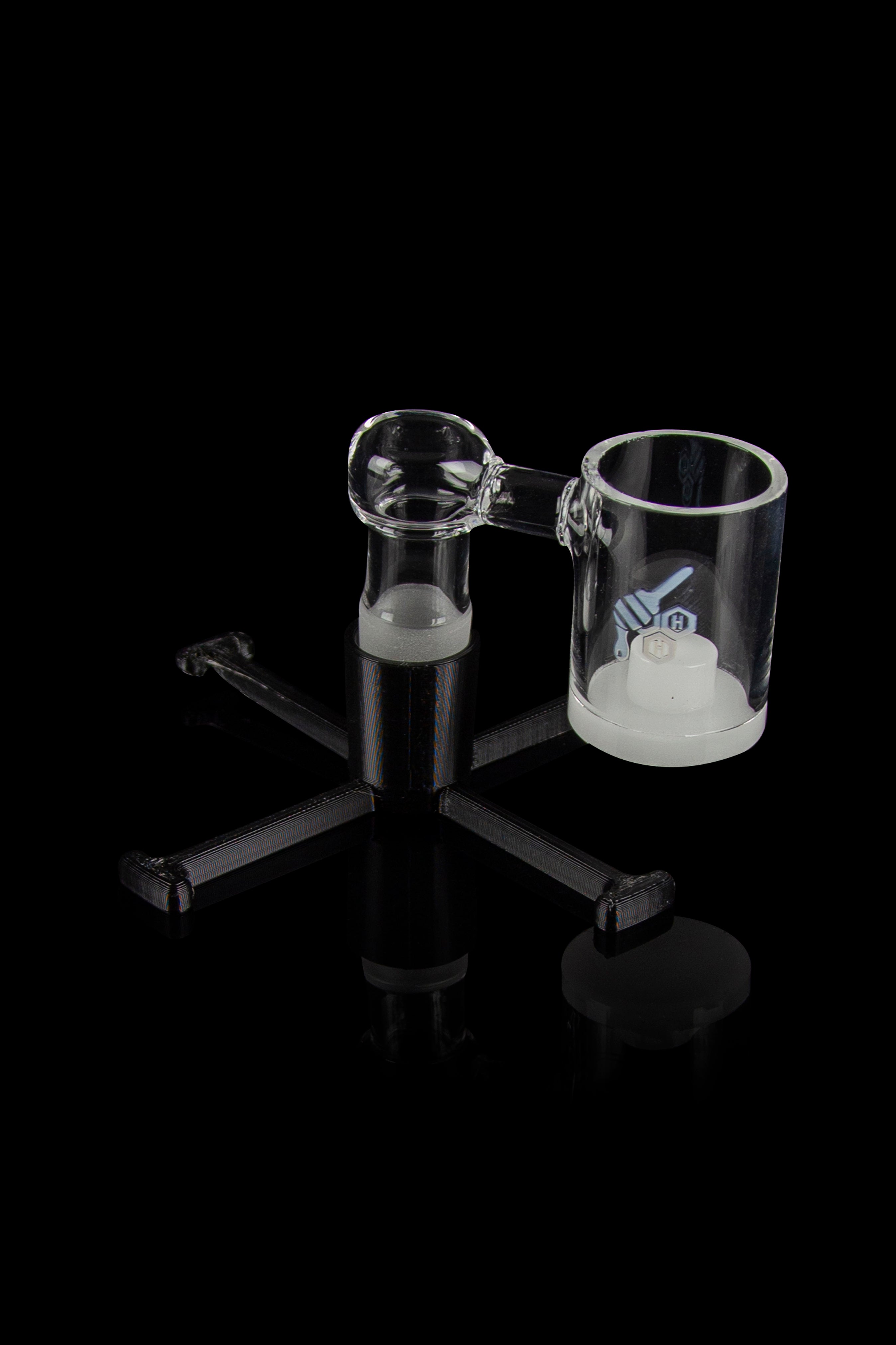 Clear glass dab rig with three attachments on a black background.