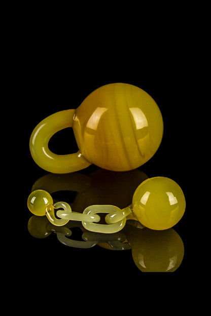 Golden glass cannabis water pipe pieces arranged on a reflective surface against a black background.