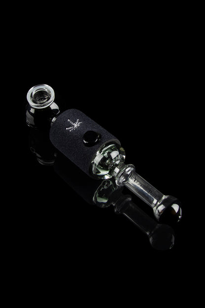 Black glass cannabis oil rig with a leaf design, isolated on a black background.