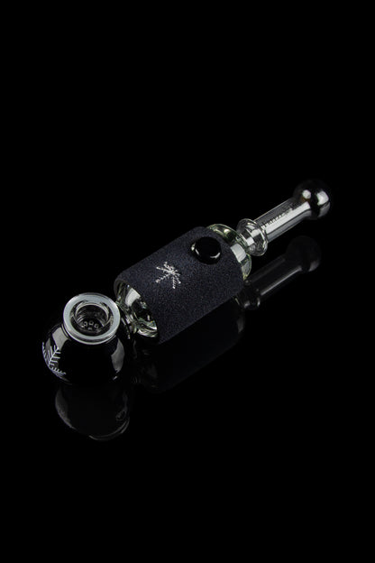 Glass pipe with black, textured wrap and reflective surface, studio shot.