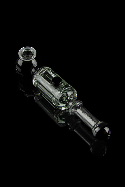 Glass cannabis oil rig with intricate bubbler design, isolated on a black background.