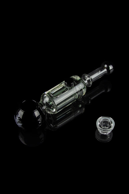 Clear glass dab rig with a quartz banger, isolated on a black reflective surface.