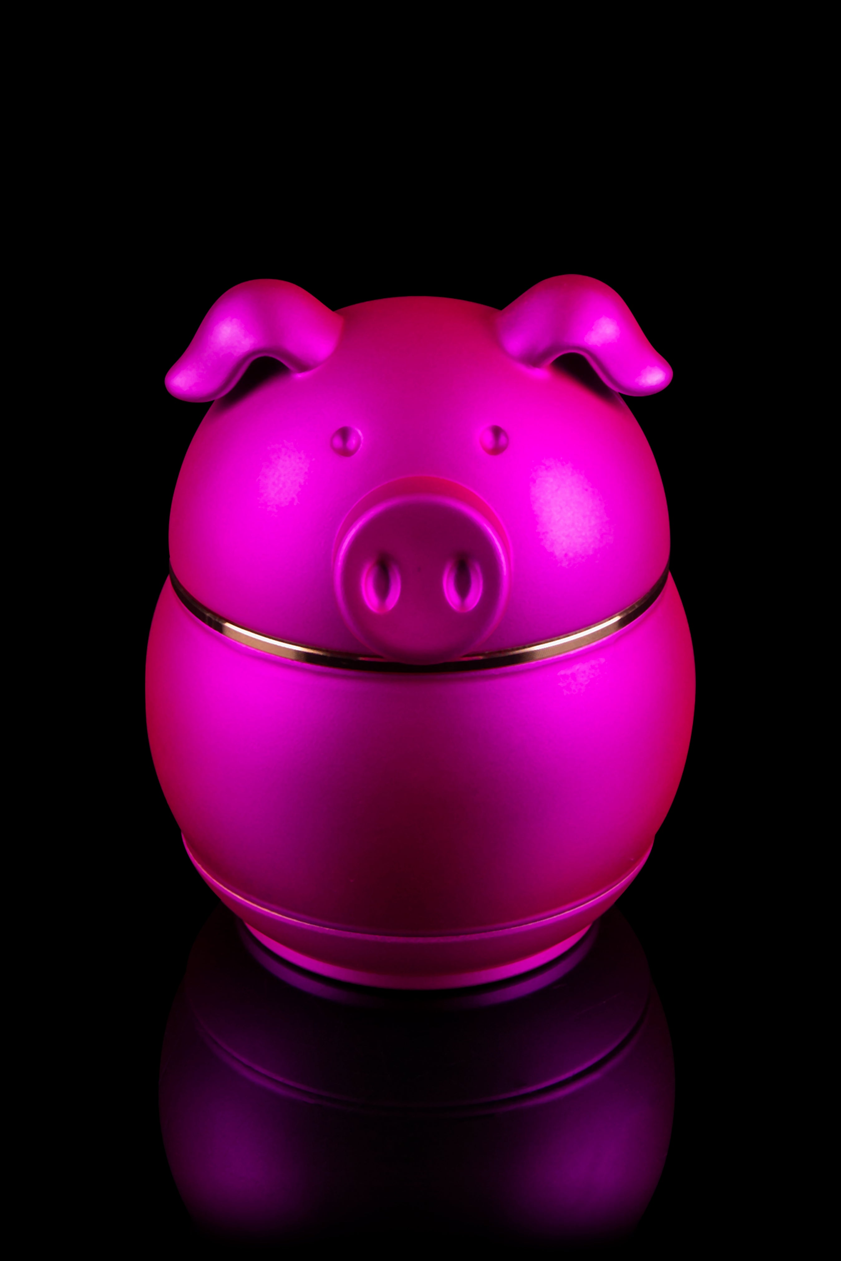 Bright pink ceramic piggy bank with a glossy finish, reflecting on a dark surface, likely used for cannabis-related savings.