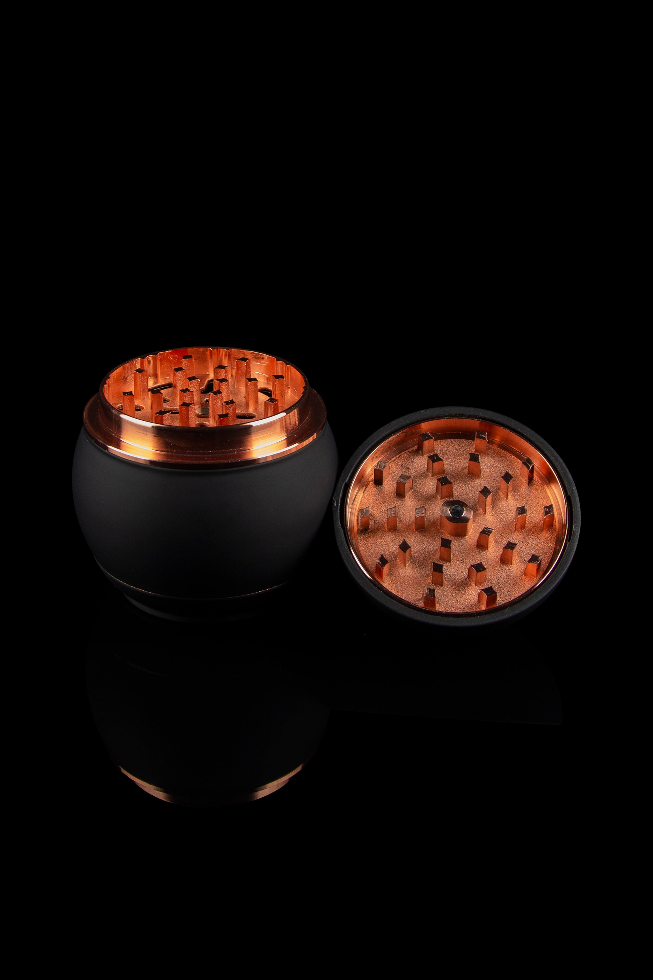 Black and copper grinder for cannabis, shown open with visible grinding teeth."