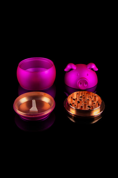 Pink pig-shaped smoking accessory set with grinder and storage containers on a black background.