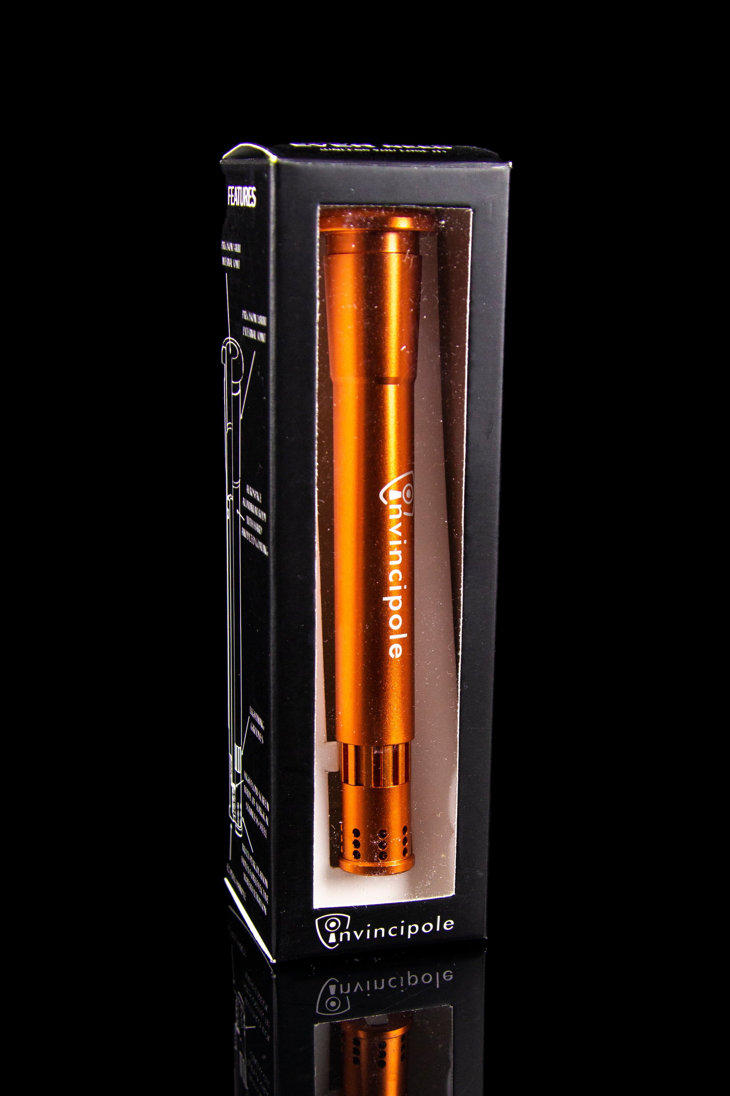 Orange cannabis pipe in a black box with “Invincipole” branding, reflected on a glossy black surface.