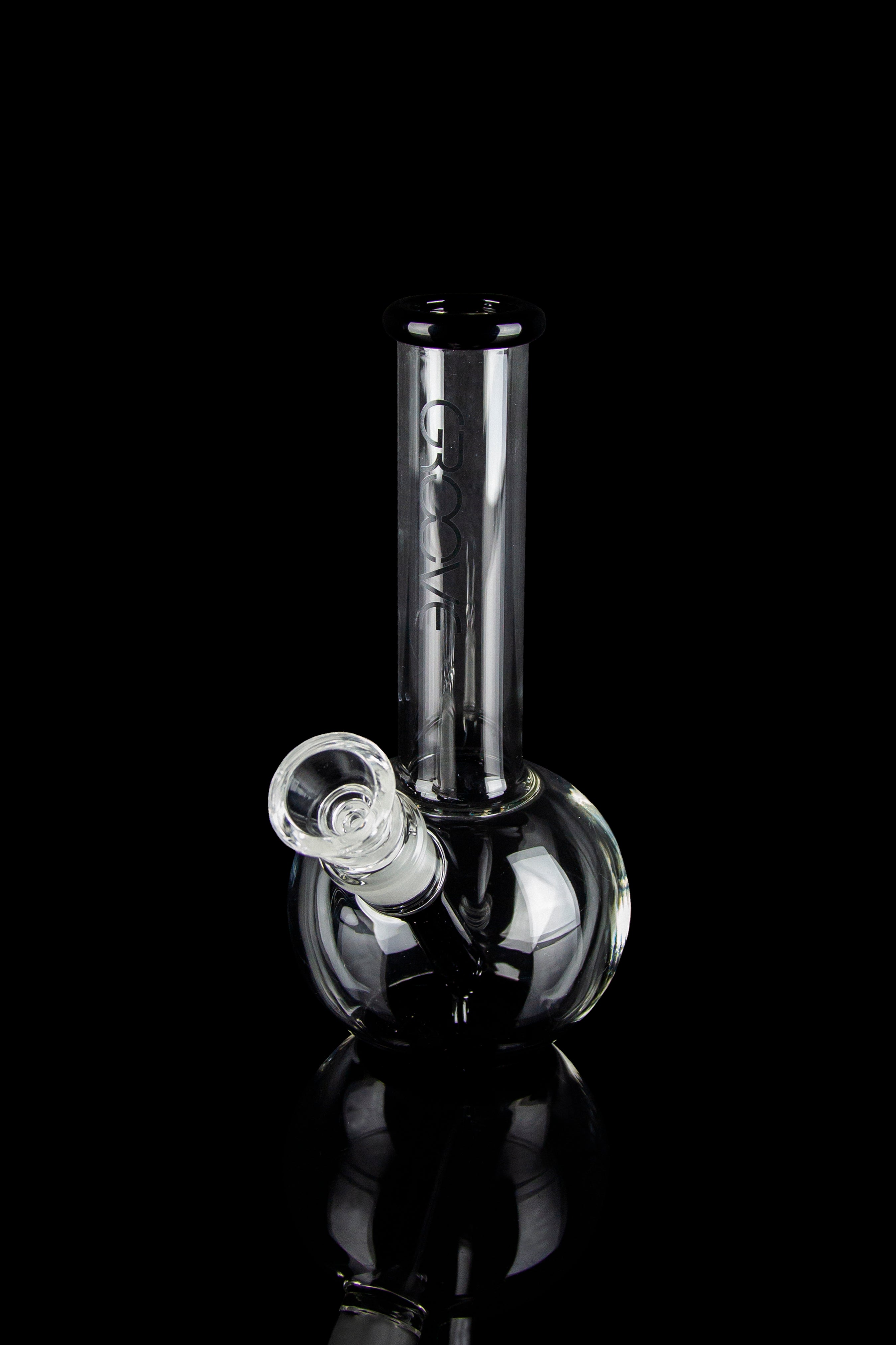 Clear glass bubbler water pipe with reflective surface, isolated on black.