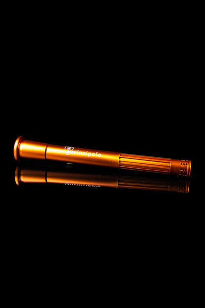 Orange cannabis oil vape pen with reflective surface, isolated on black.