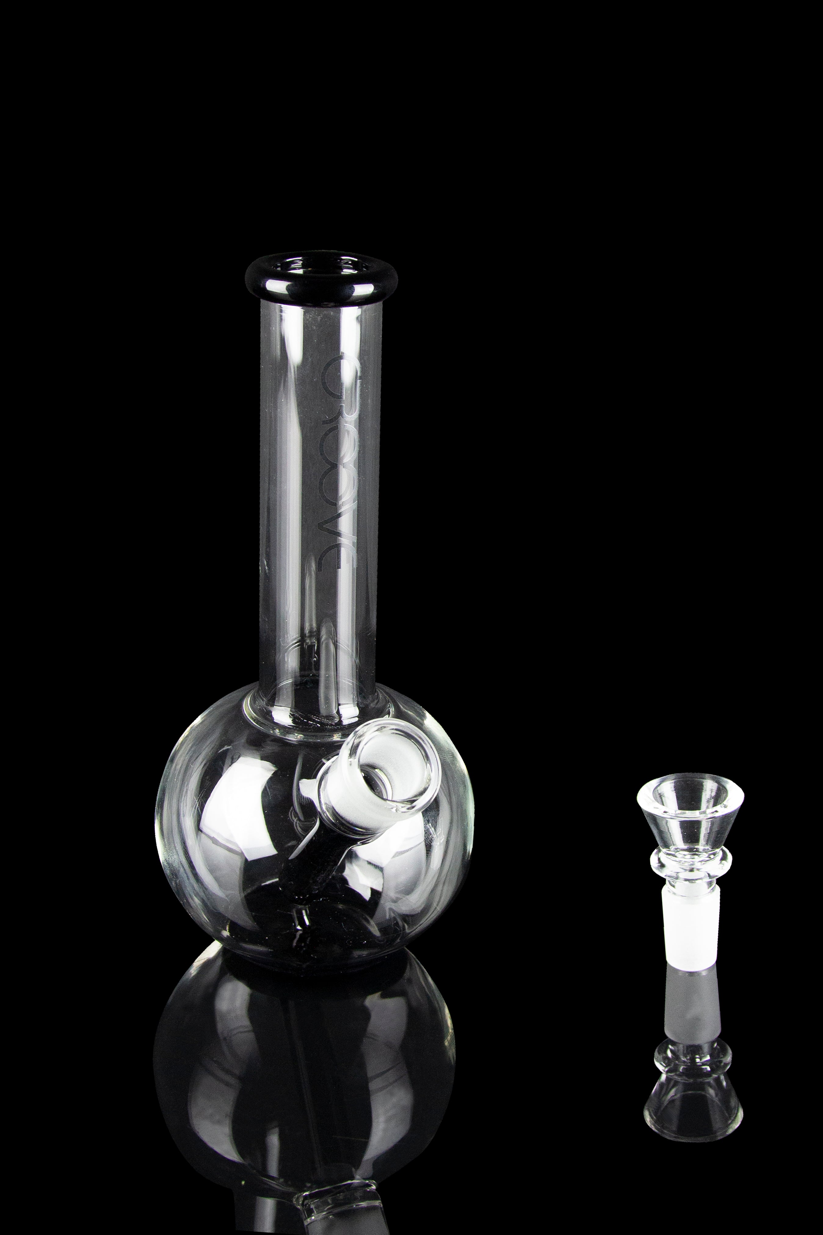 Glass bubbler and bowl for smoking cannabis, studio shot on black background.