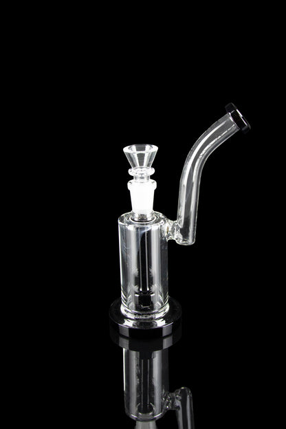 Clear glass bubbler with a flared mouthpiece and angled neck, reflecting on a dark surface.