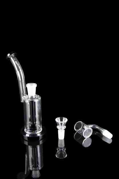 Clear glass bubbler and attachments on a black reflective surface.