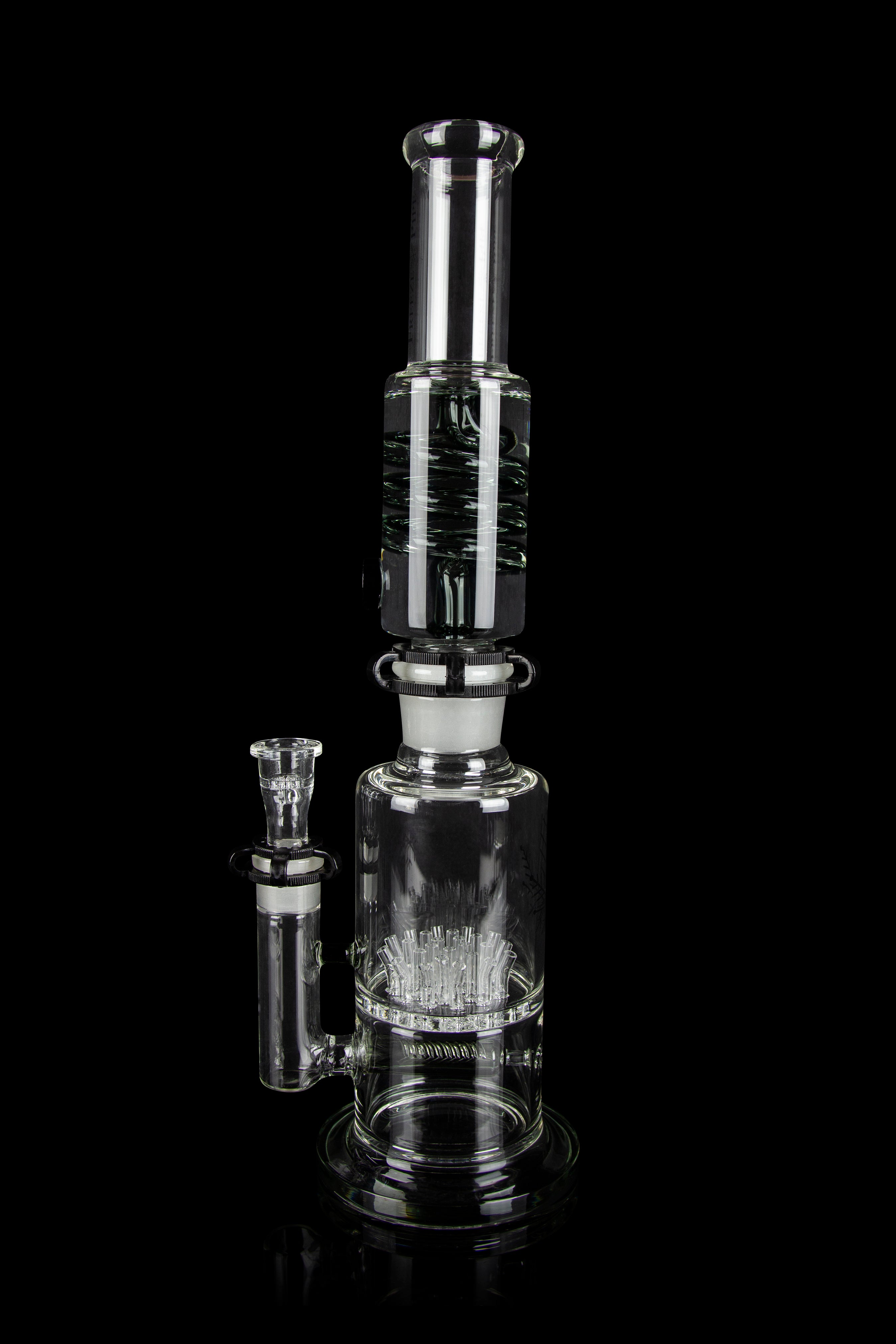Clear glass water pipe (rig) with intricate percolator design, isolated on a black background.