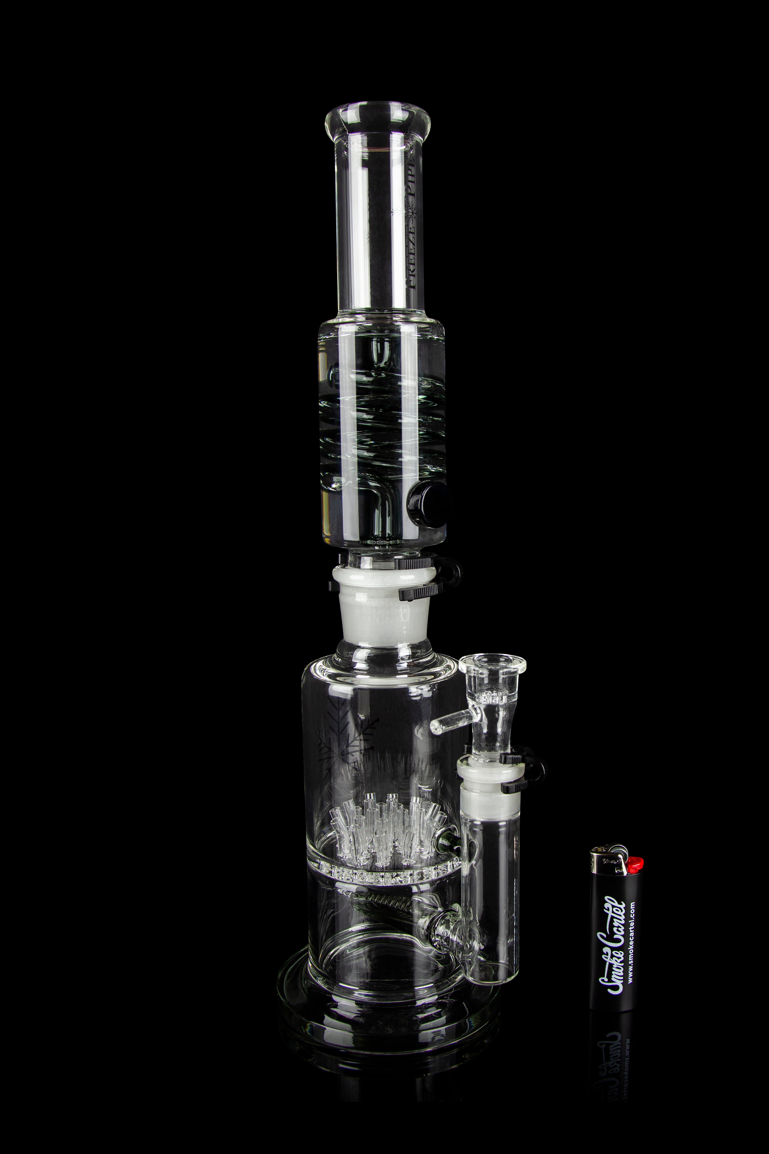 Clear glass water pipe (bong) with intricate percolator design, studio shot on black background.