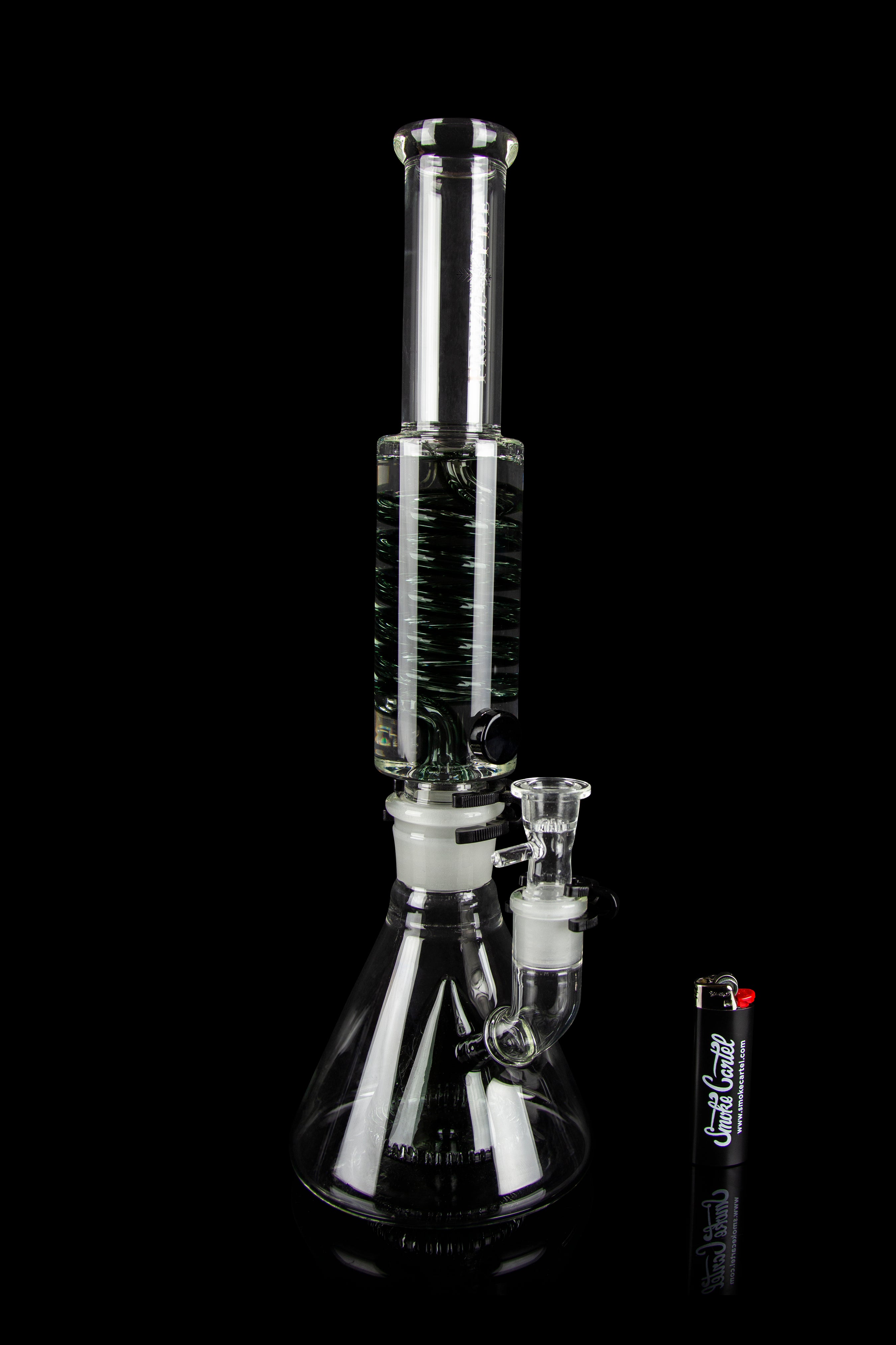 Glass bong with black and white striped percolator, isolated on a black background.