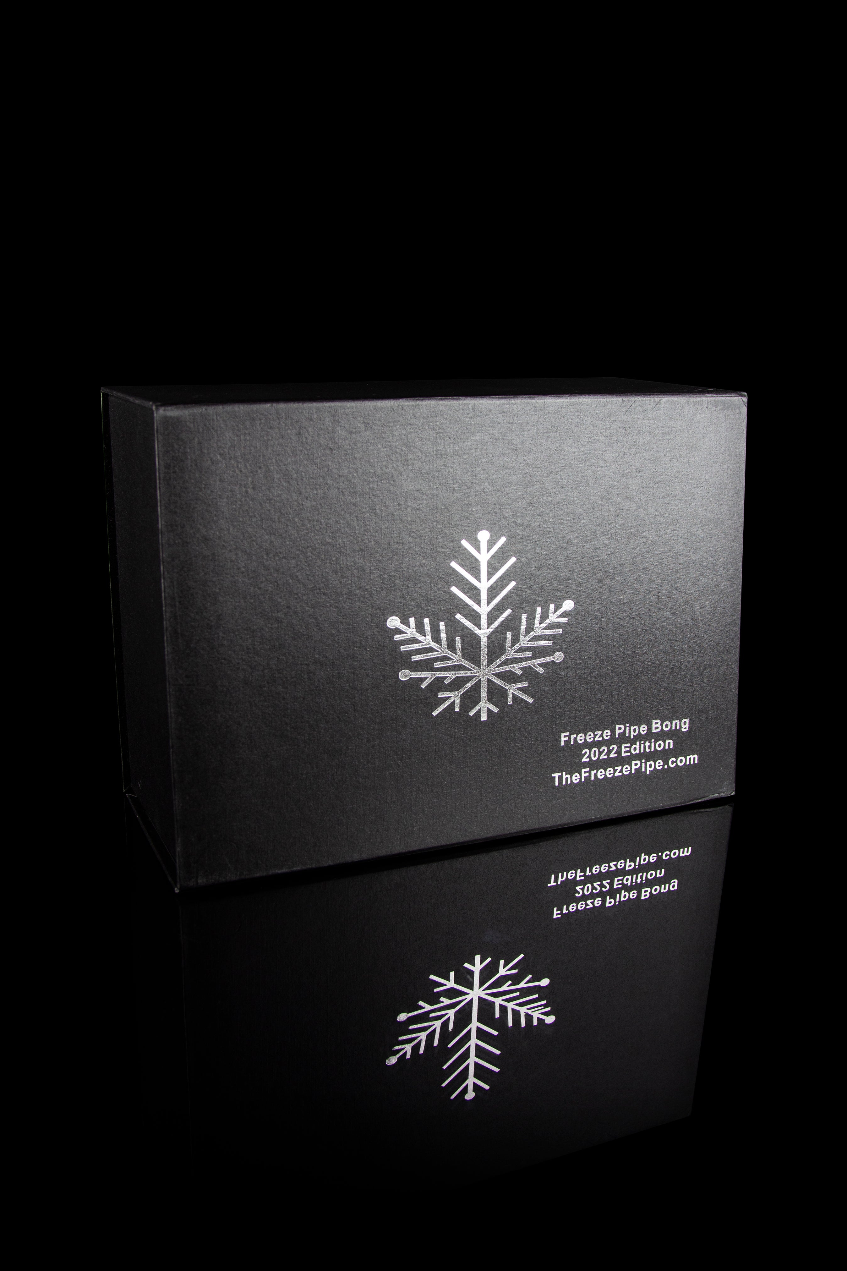 Black box for a cannabis accessory, featuring a white snowflake design and text reading “Freeze Pipe Bong 2022 Edition” and website address.
