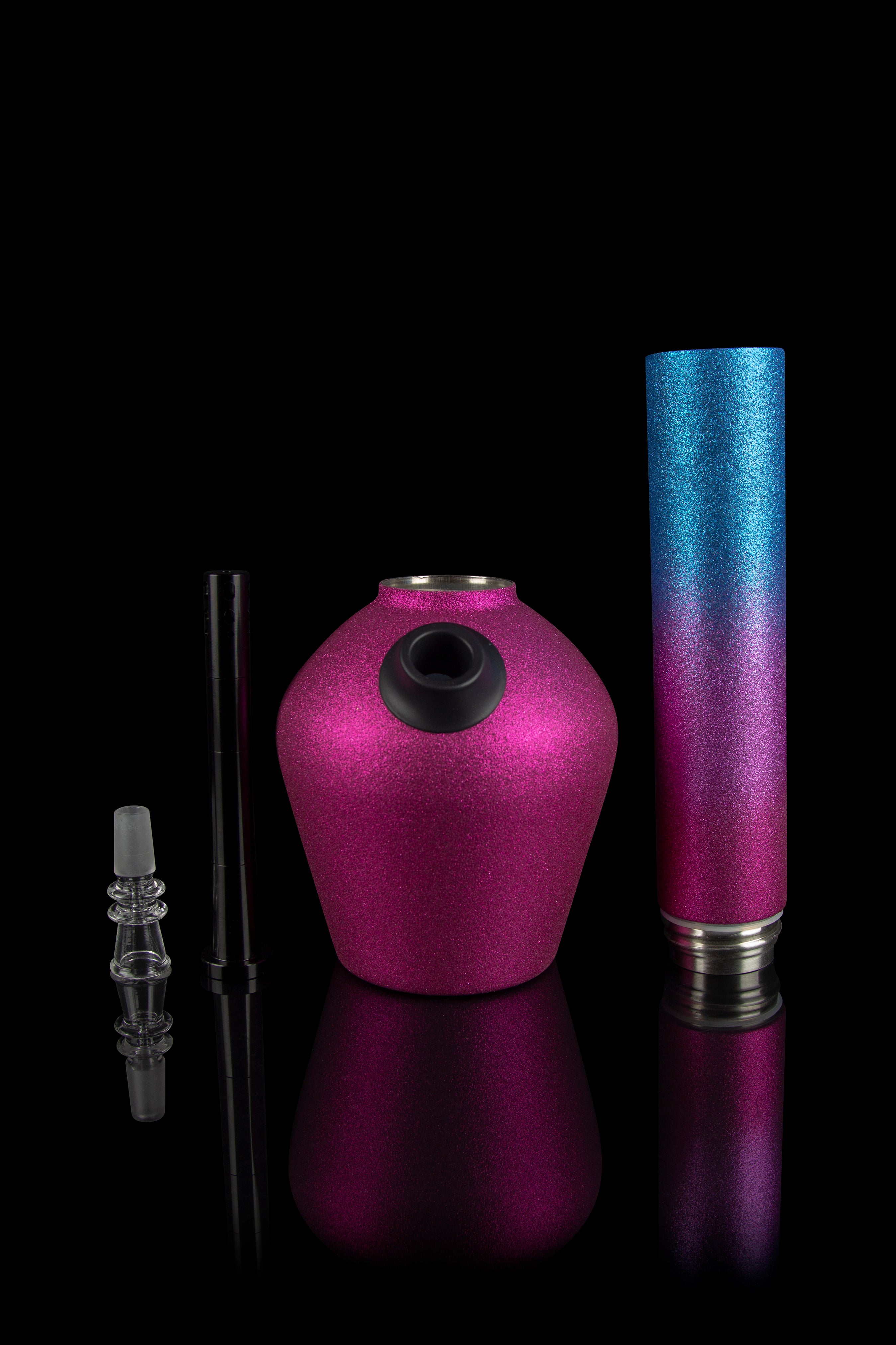 Glittering pink and blue cannabis water pipe components displayed on a reflective black surface.