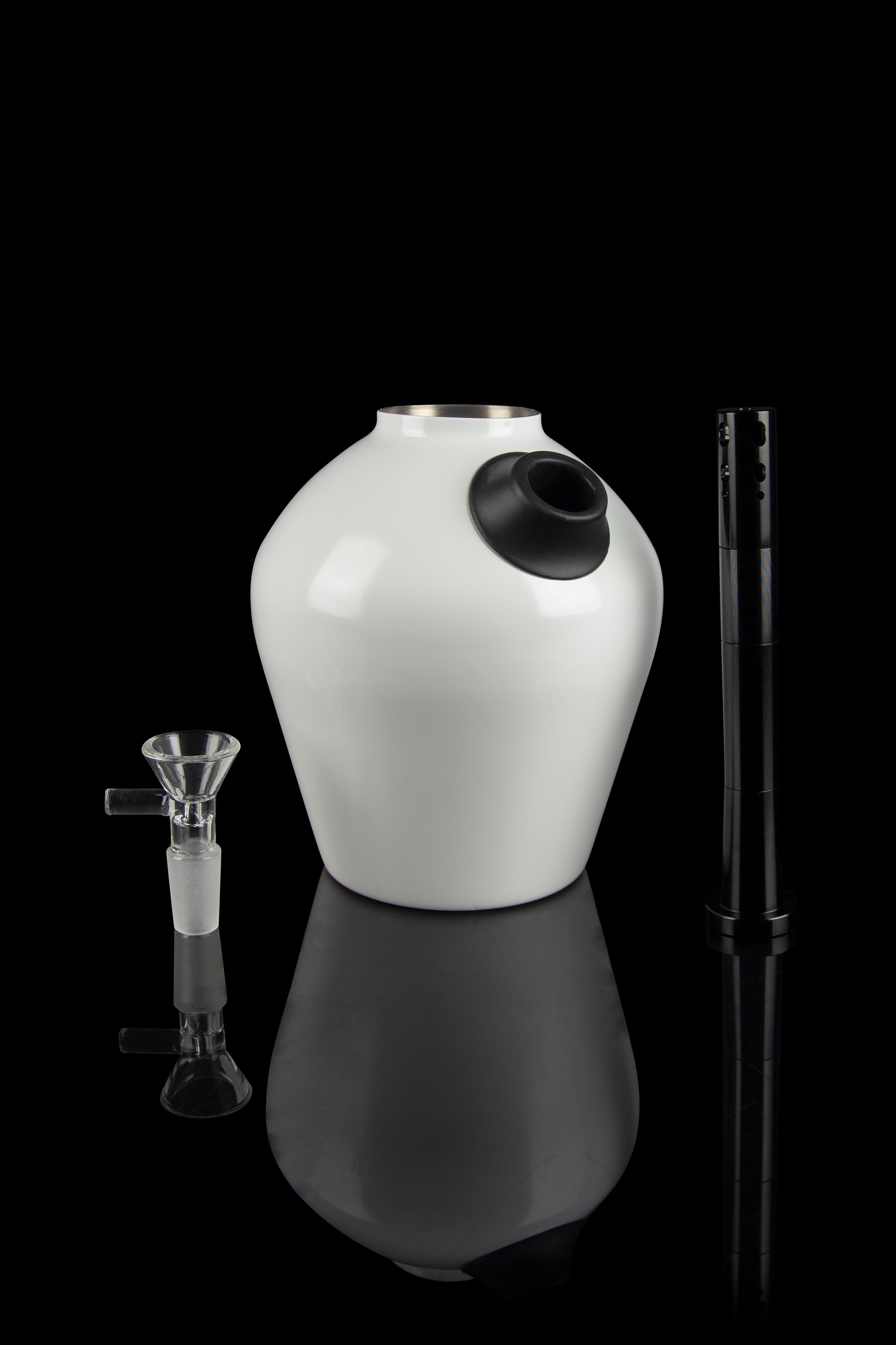 White glass water pipe with a downstem and tool, studio shot on a black reflective surface.