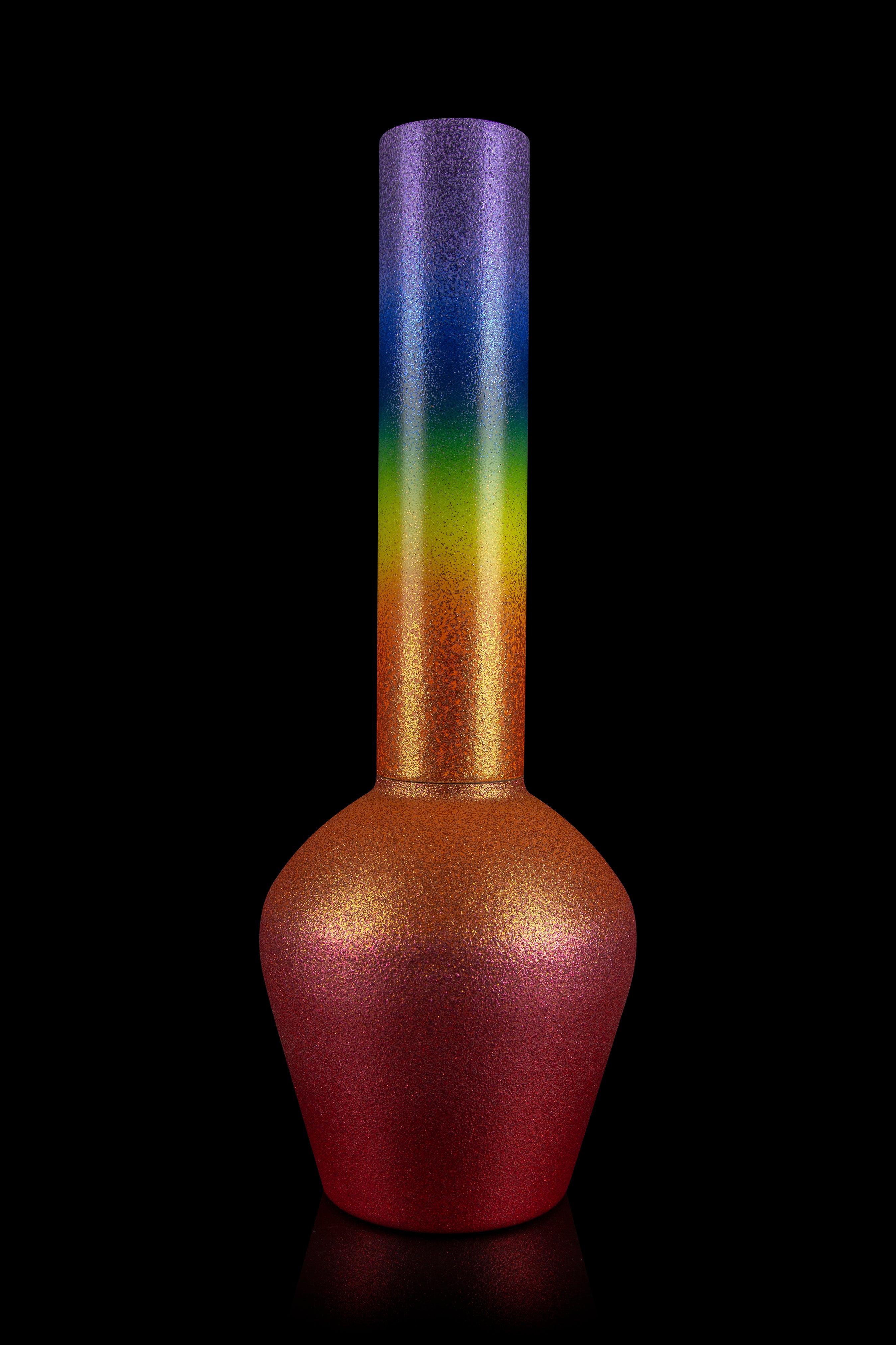 Rainbow-colored glass water pipe against a black background.