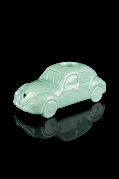 Mint green Volkswagen Beetle-shaped glass pipe with a glossy reflective surface.