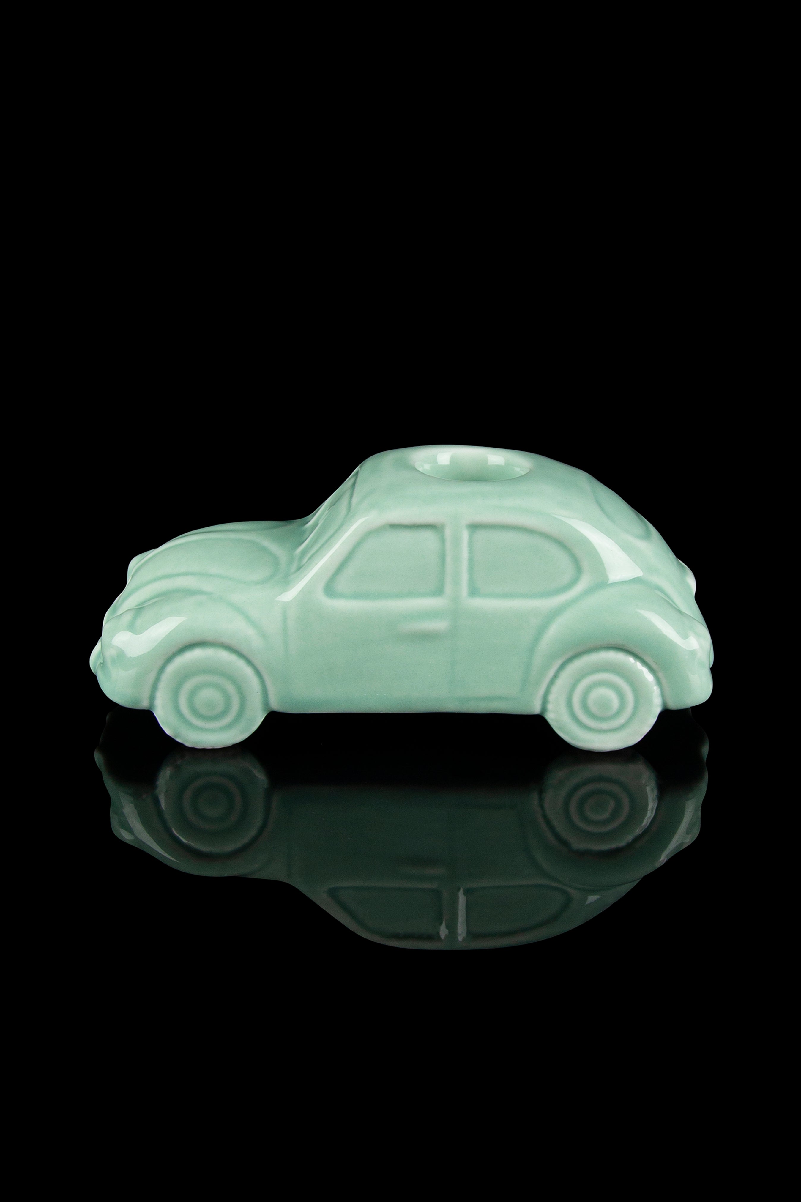 Mint green Volkswagen Beetle-shaped glass piece with reflective surface.