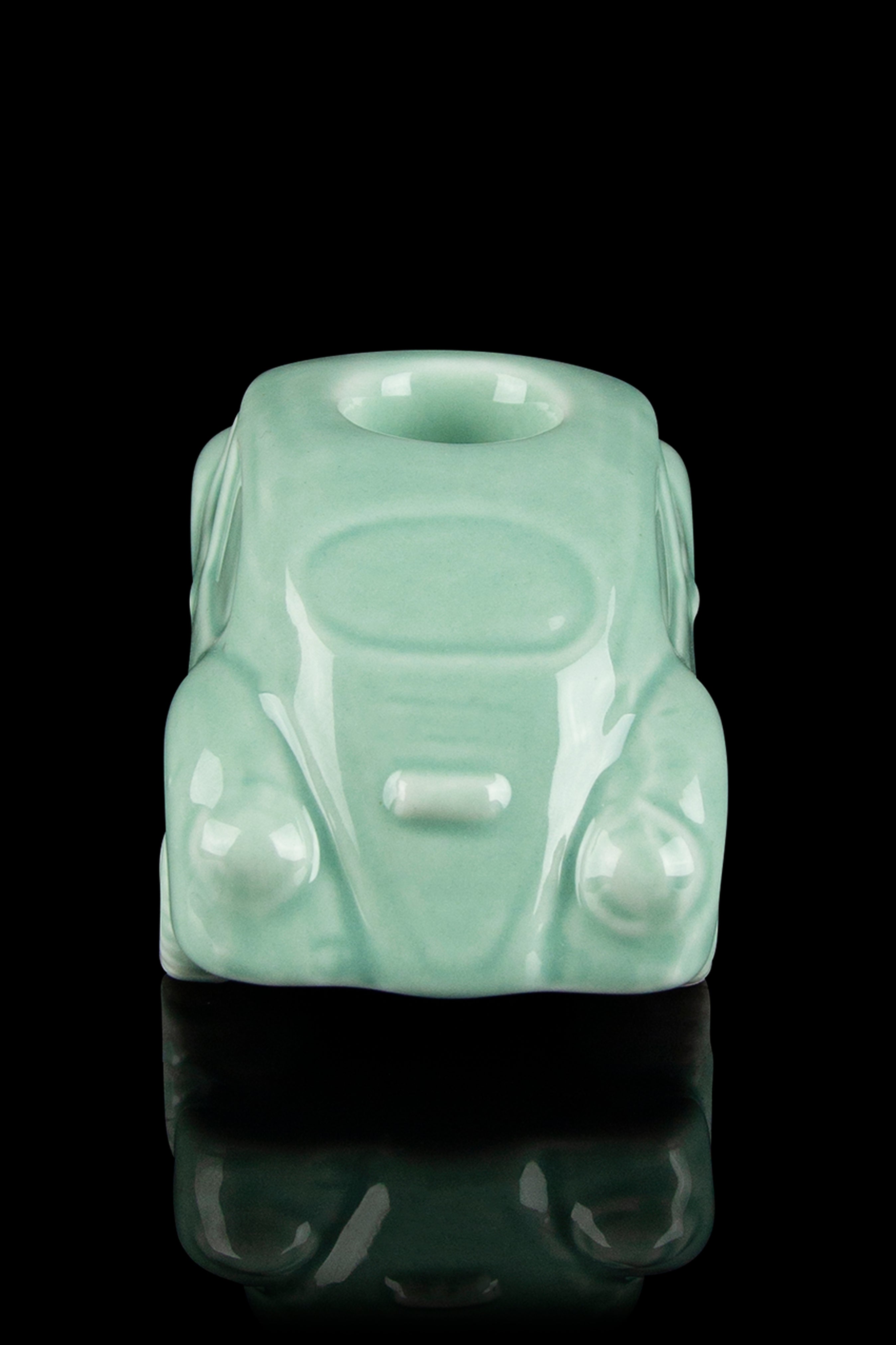 Mint green glass cannabis water pipe shaped like a classic Volkswagen Beetle, displayed on a reflective surface.