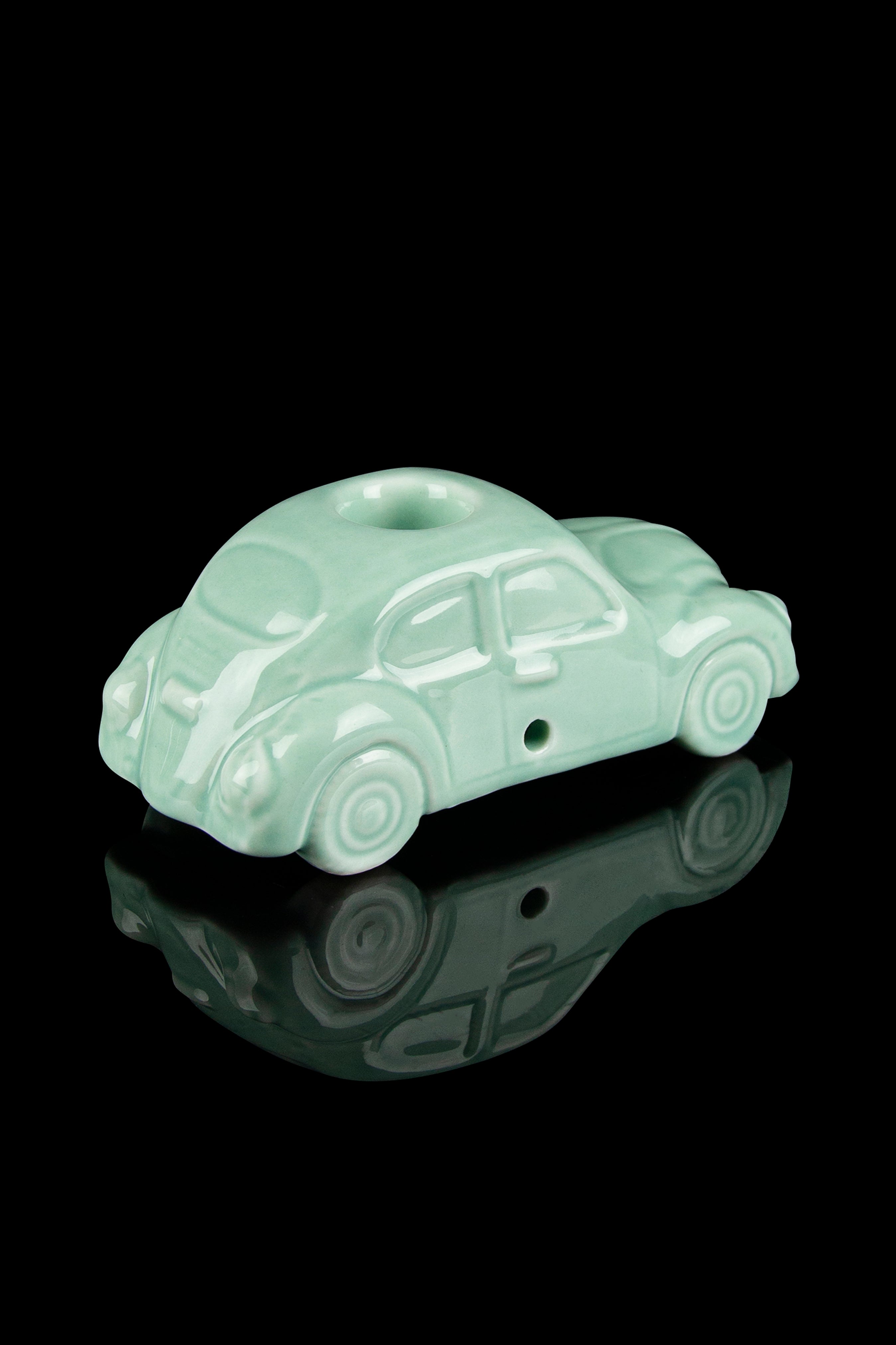 Mint green glass pipe shaped like a vintage car with a reflective surface.