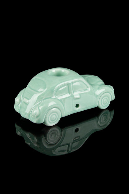Mint green glass pipe shaped like a vintage car with a reflective surface.