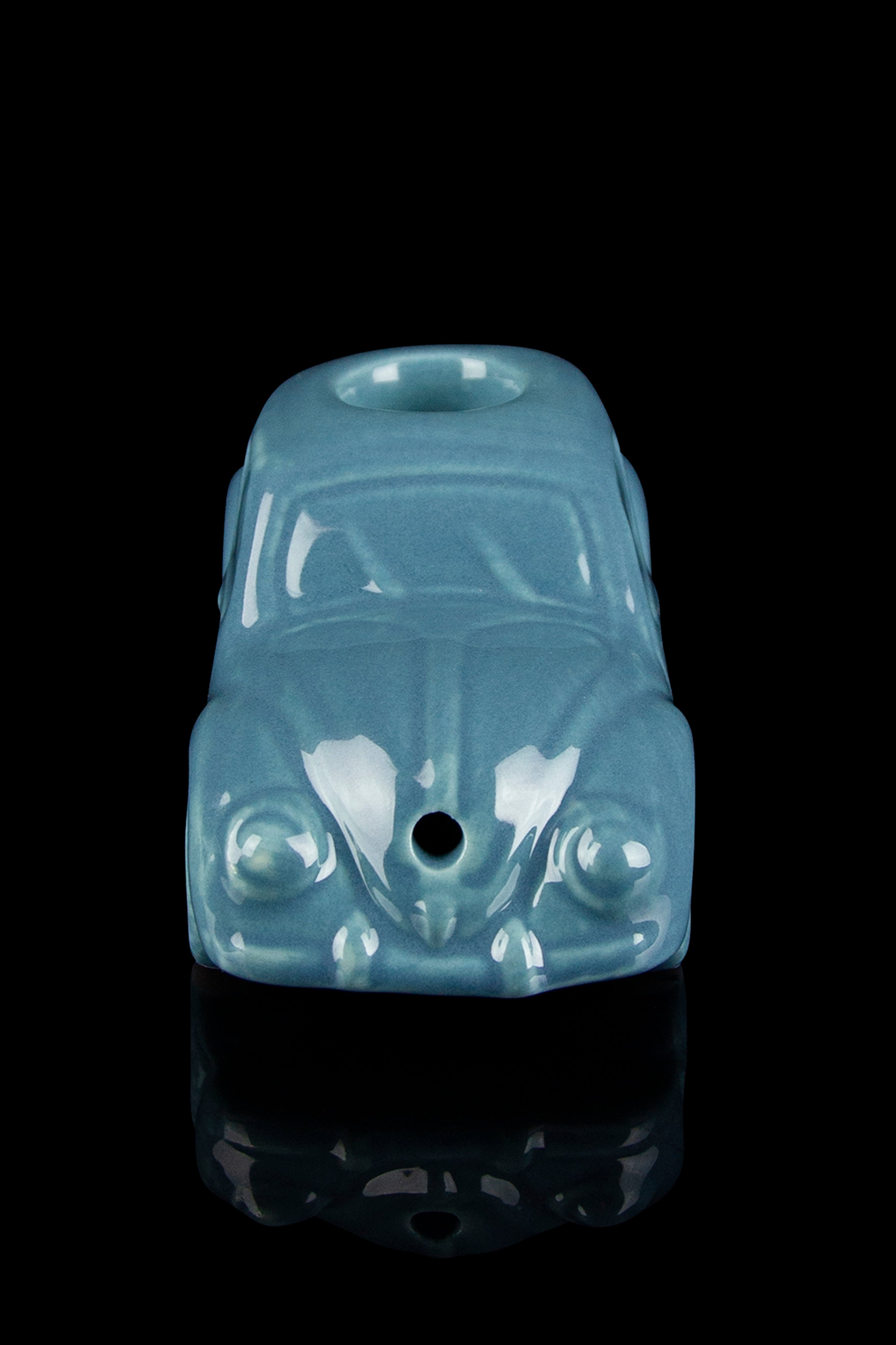 Teal Volkswagen Beetle-shaped glass pipe against a black background.