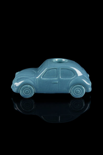 Turquoise Volkswagen-shaped glass piece with a reflective surface, likely a cannabis smoking accessory.