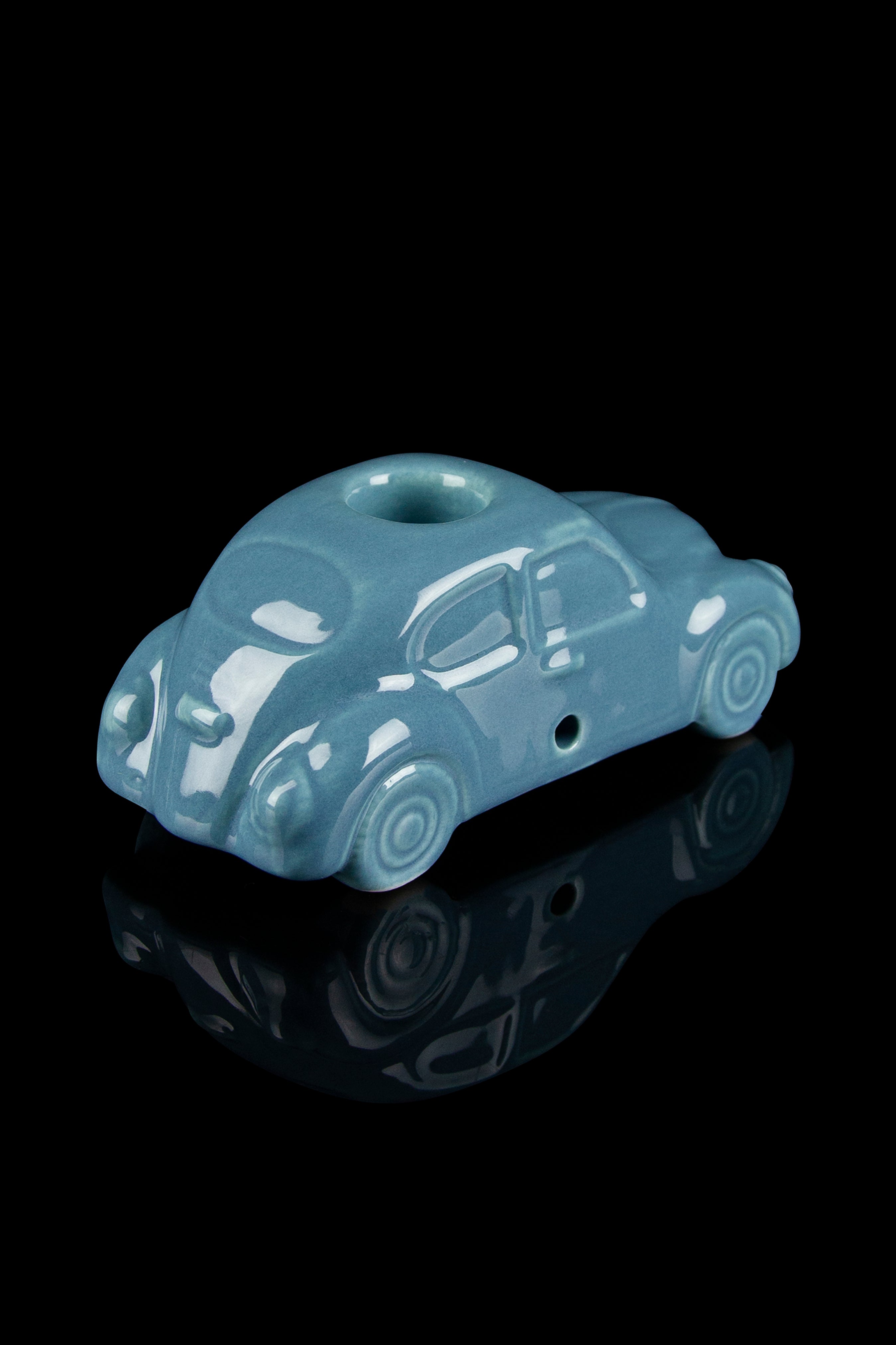 Ceramic pipe shaped like a vintage turquoise car with a glossy reflective surface.