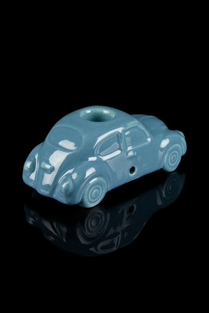 Ceramic pipe shaped like a vintage turquoise car with a glossy reflective surface.