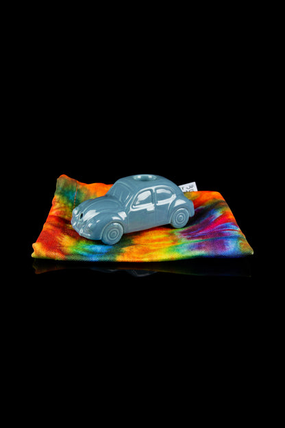 Blue Volkswagen Beetle car resting on a vibrant tie-dye cloth, likely a cannabis accessory storage bag.
