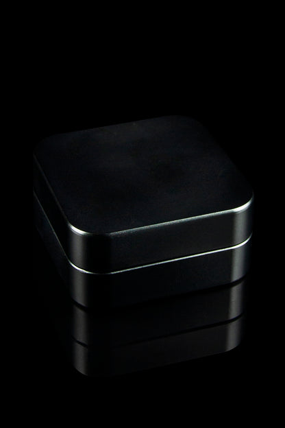 Sleek black storage container, possibly for cannabis or accessories, dramatically lit against a dark background.