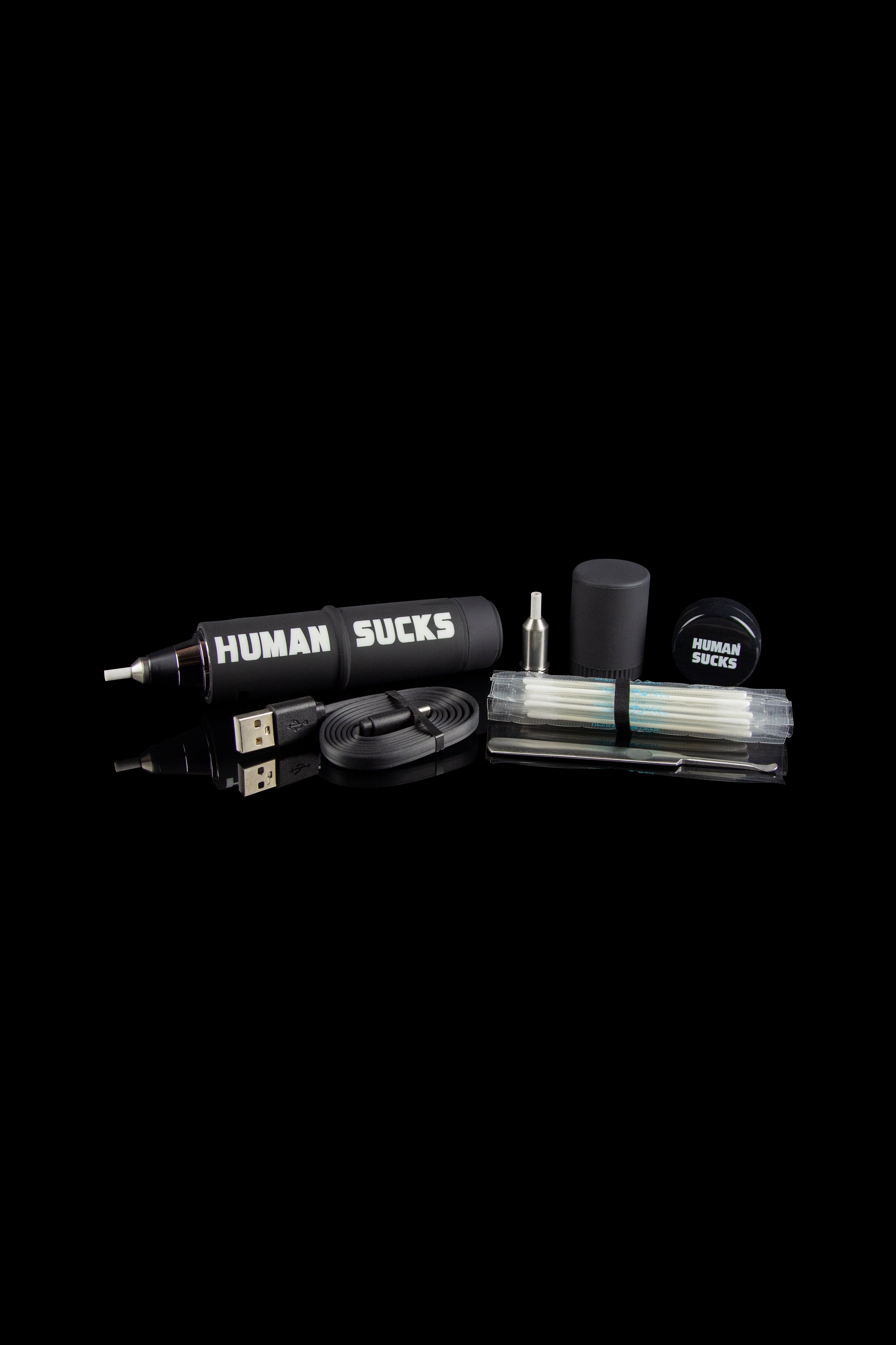 Cannabis vaping kit with pen, charger, and accessories on a black background, branded with “HUMAN SUCKS.”