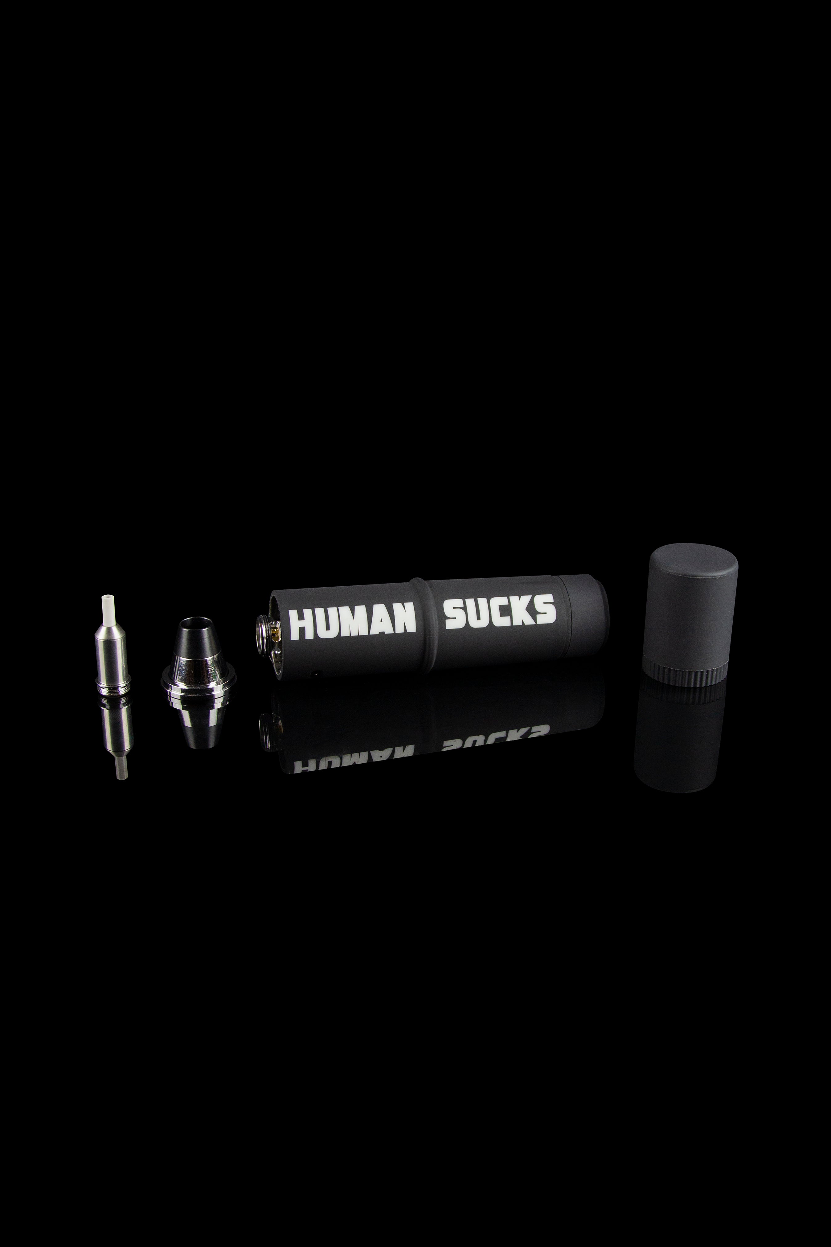 Cannabis oil vape pen components displayed on a black background with "HUMAN SUCKS" printed on the battery.