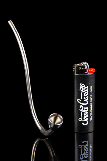Silver glass pipe and lighter on a black reflective surface.