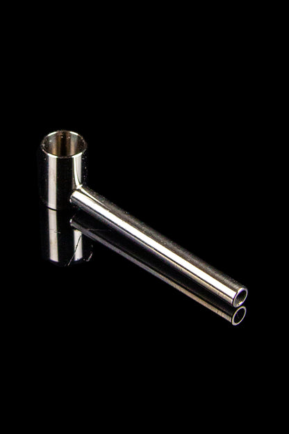 Silver cannabis oil burner pipe against a black background.