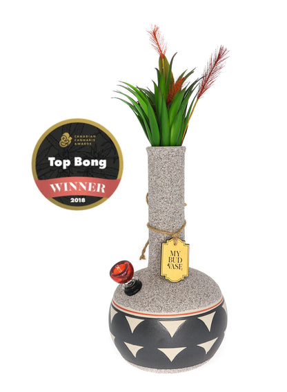 Front view of the My Bud Vase Coyōté water pipe, displaying a textured gray base and red feather accent.