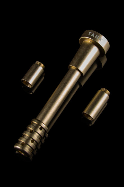Gold-toned cannabis oil vaporizer components isolated on black.