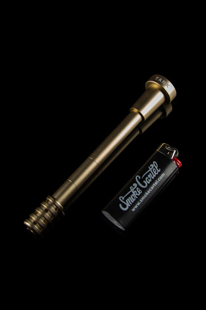 Gold cannabis oil vaporizer pen with a branded lighter on a black background.