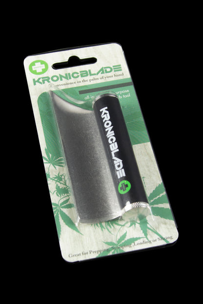 A packaged cannabis accessory, the “Kronicblade,” a cylindrical tool for prepping, scooping, and loading cannabis, displayed against a green leaf background.