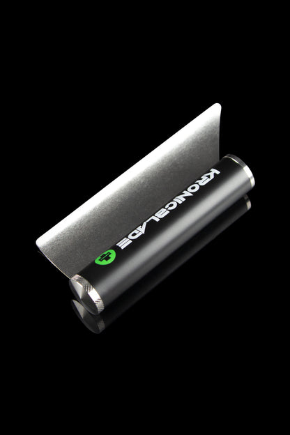 Sleek black cannabis grinder with green branding, angled on a black background.