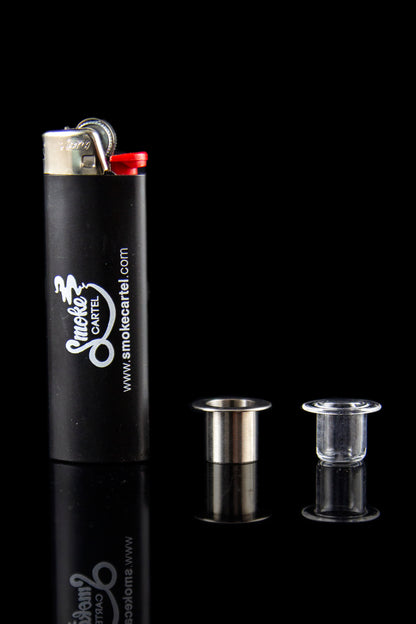 Black lighter with “Smoke Cartel” branding alongside glass oil rig attachments reflecting on a dark surface.