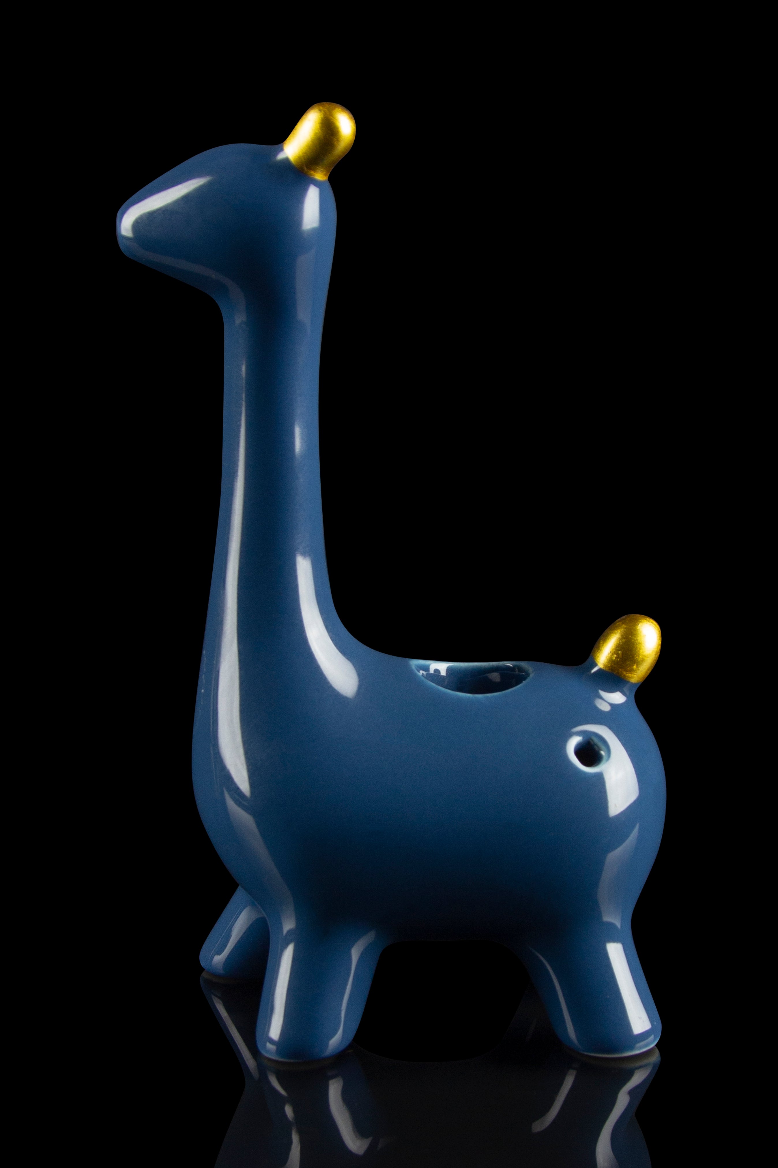 Blue giraffe-shaped glass pipe with gold accents, reflecting on a glossy black surface.