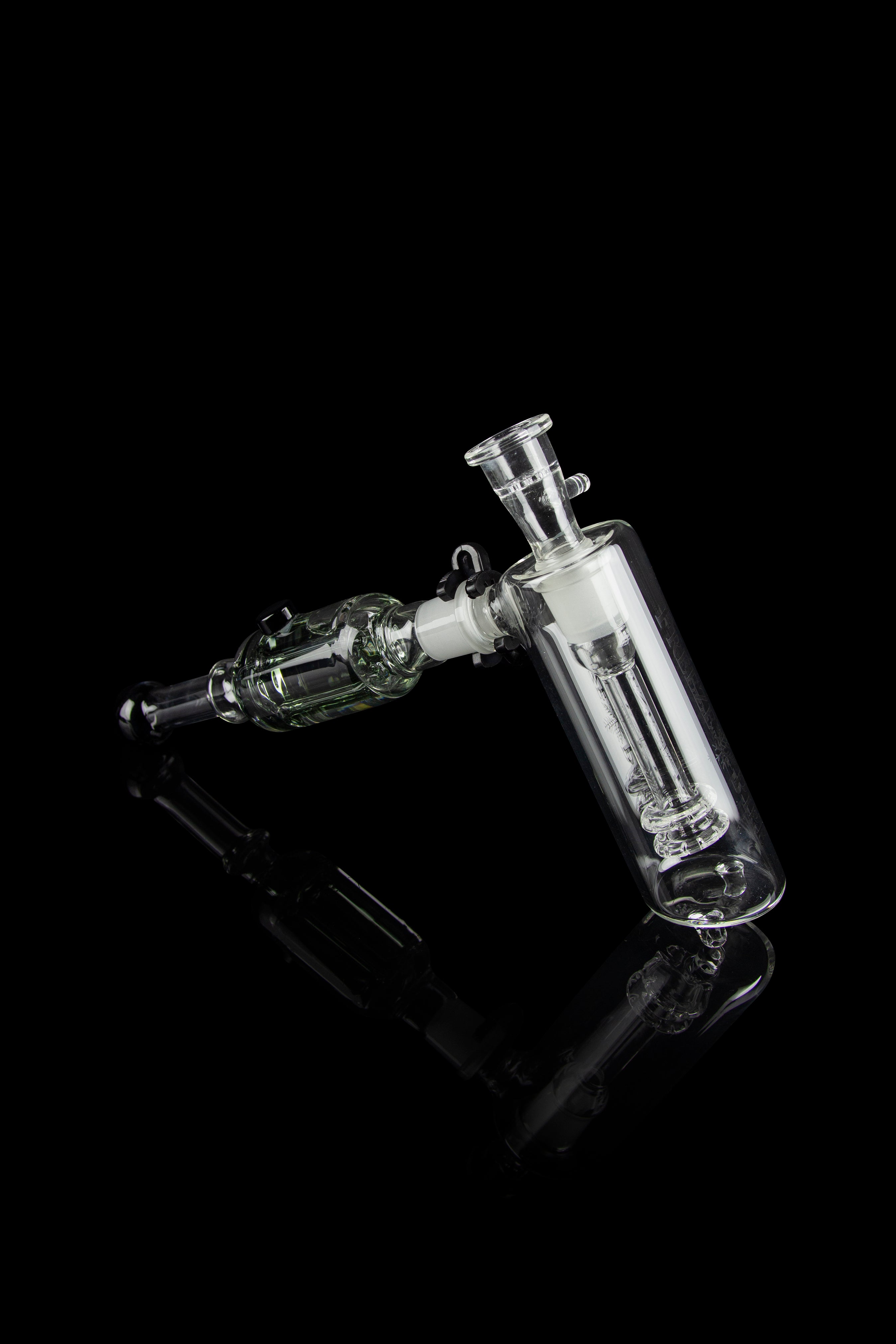 Clear glass water pipe (rig) with intricate bubbler design, isolated on black.
